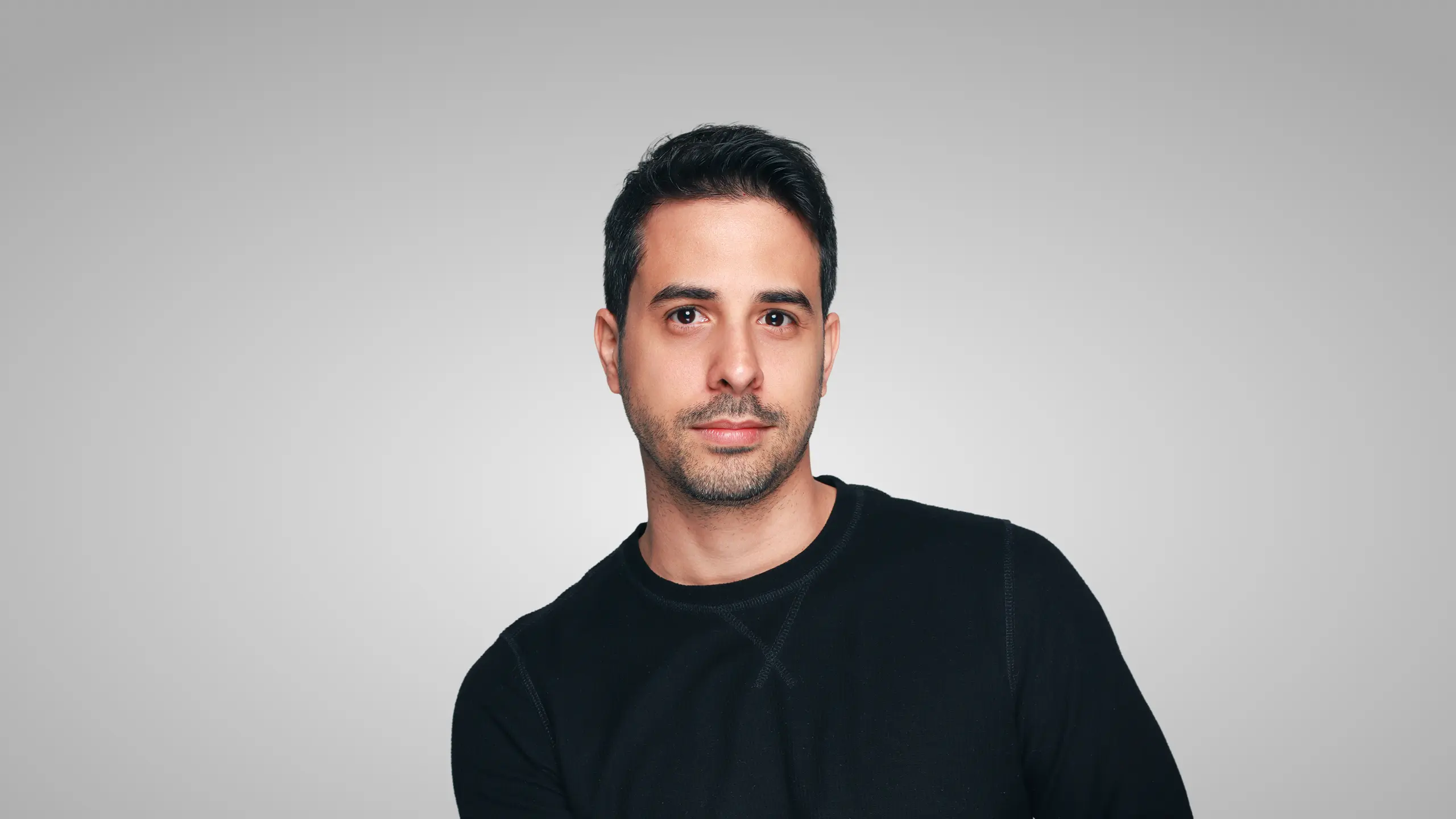 Profile portrait of a man in a white shirt against a light background